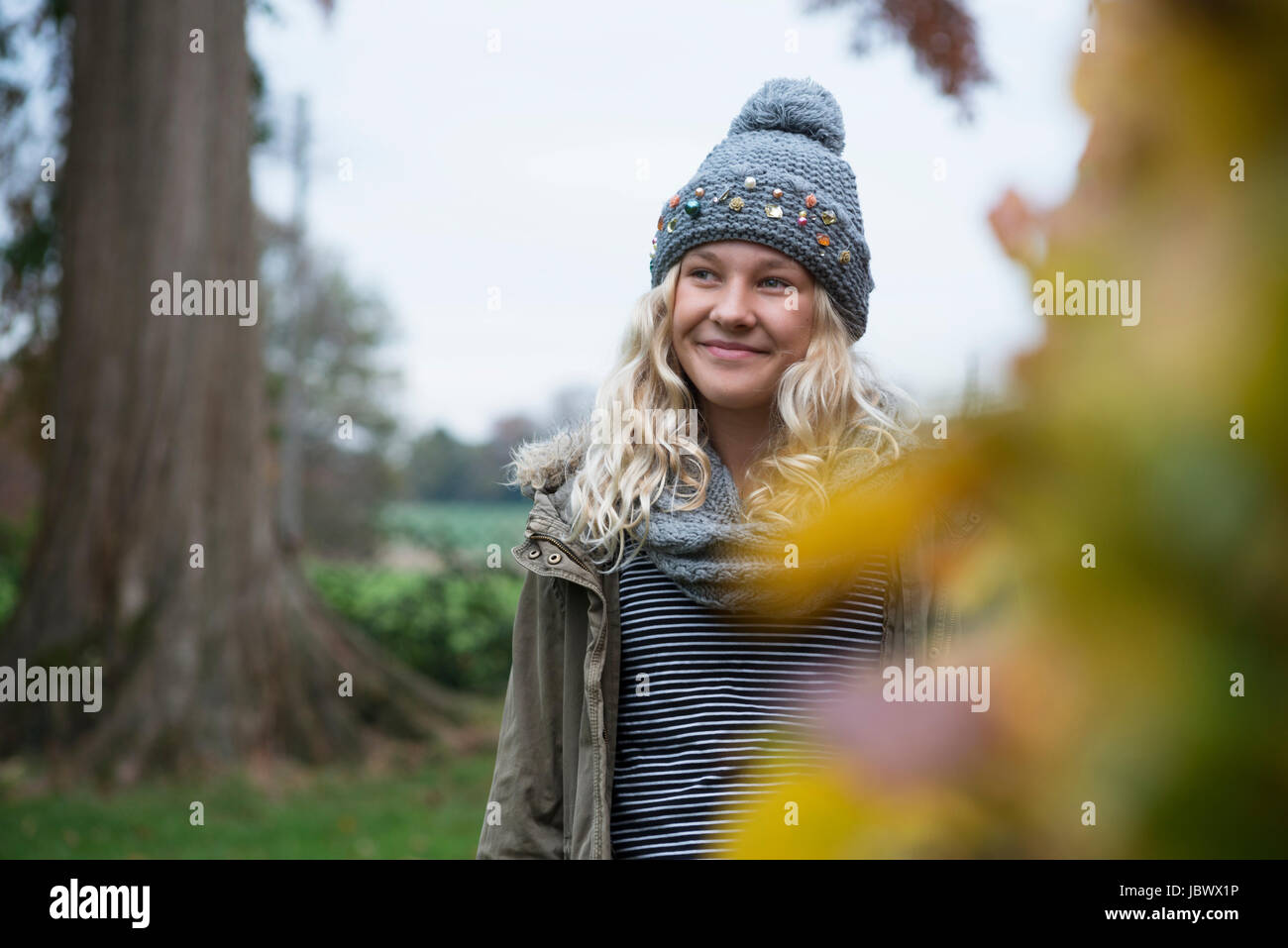 Girl in knit hat strolling in rural landscape Stock Photo