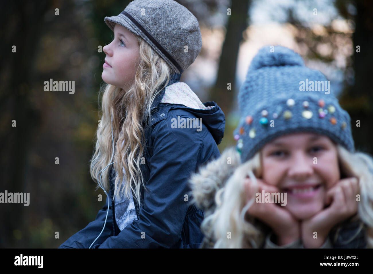 Portrait of girl and her sister in rural landscape wearing knit hat Stock Photo