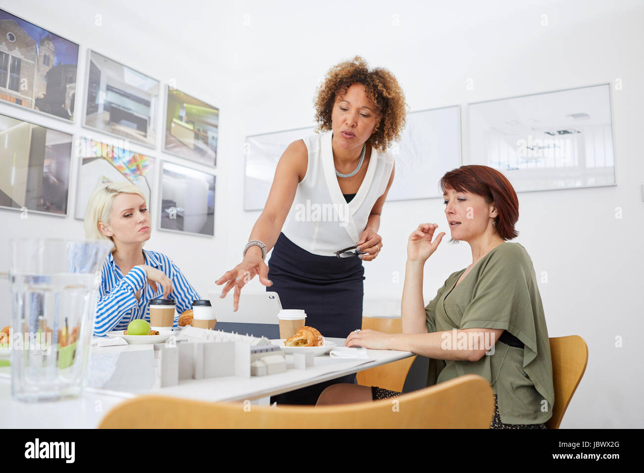 Female architect team pointing at architectural model on table in meeting Stock Photo