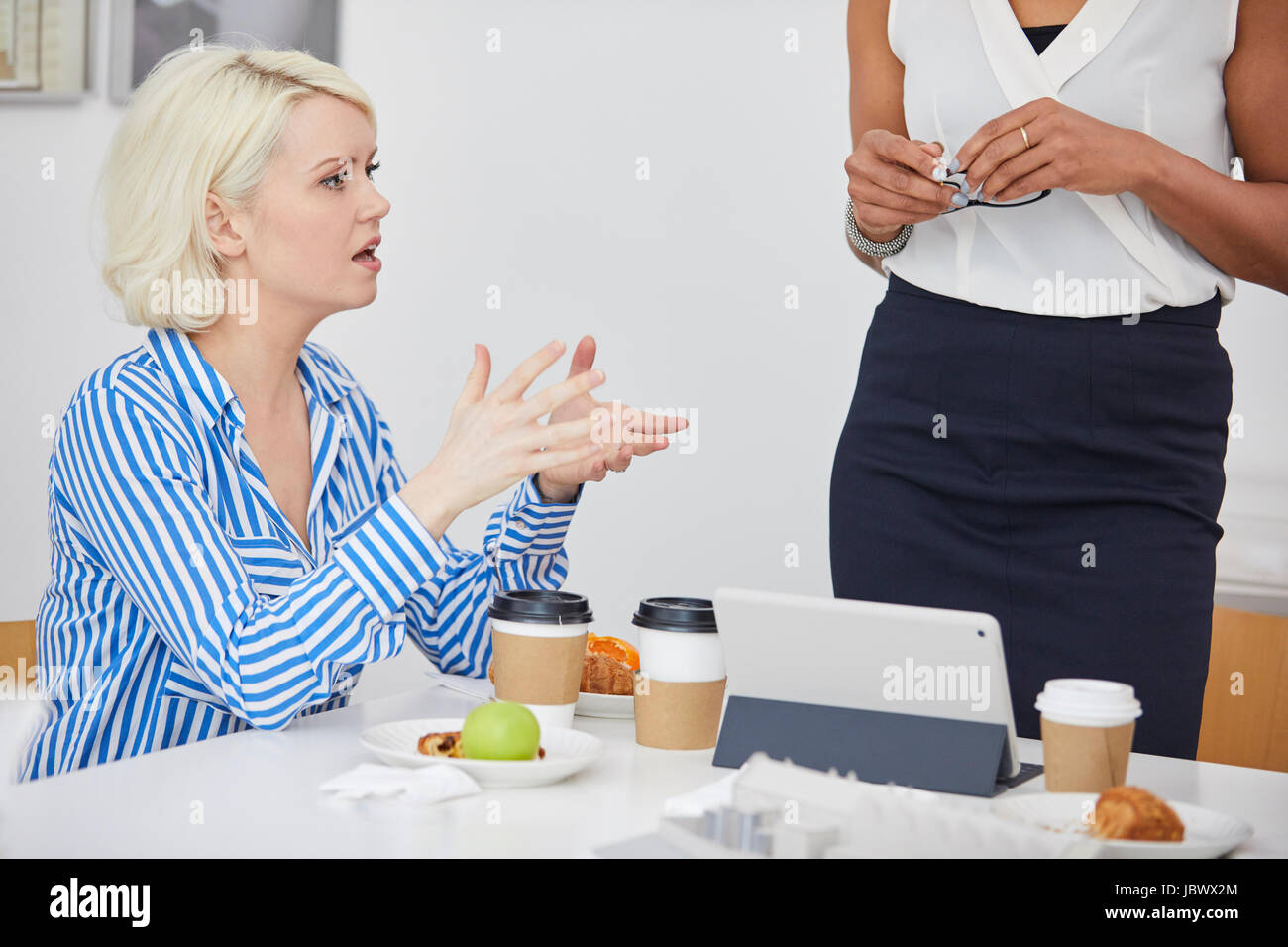 Female architect explaining architectural model on table in meeting Stock Photo