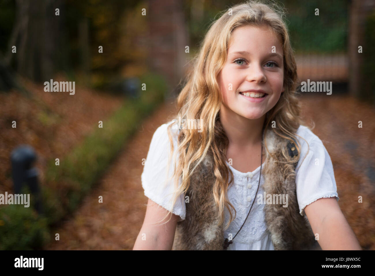 Portrait of blond haired girl in autumn park Stock Photo