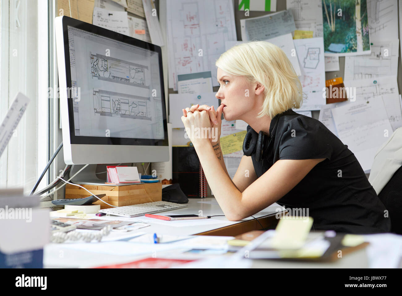 Female designer staring from office desk Stock Photo