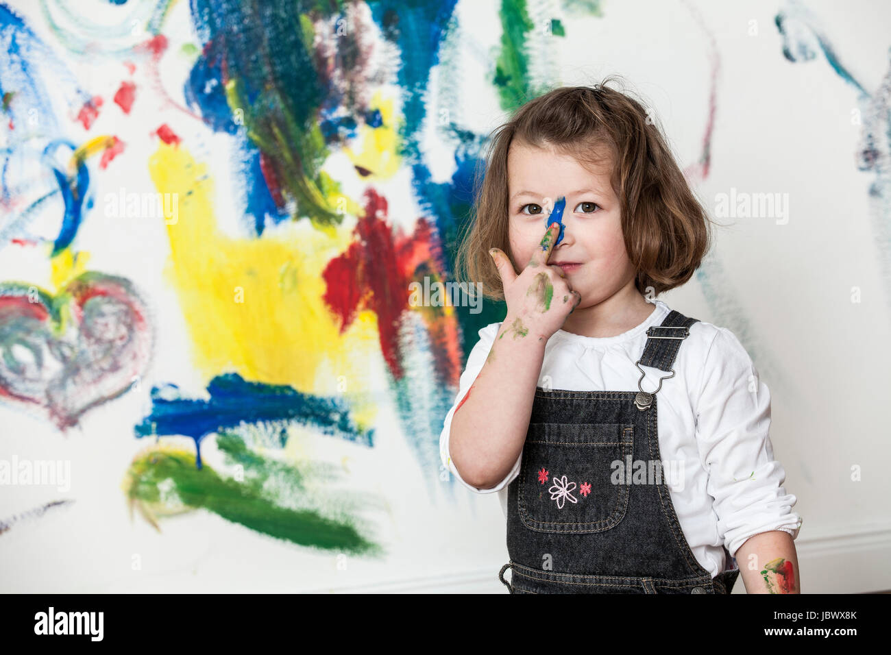 Little girl in front of painted white wall Stock Photo - Alamy