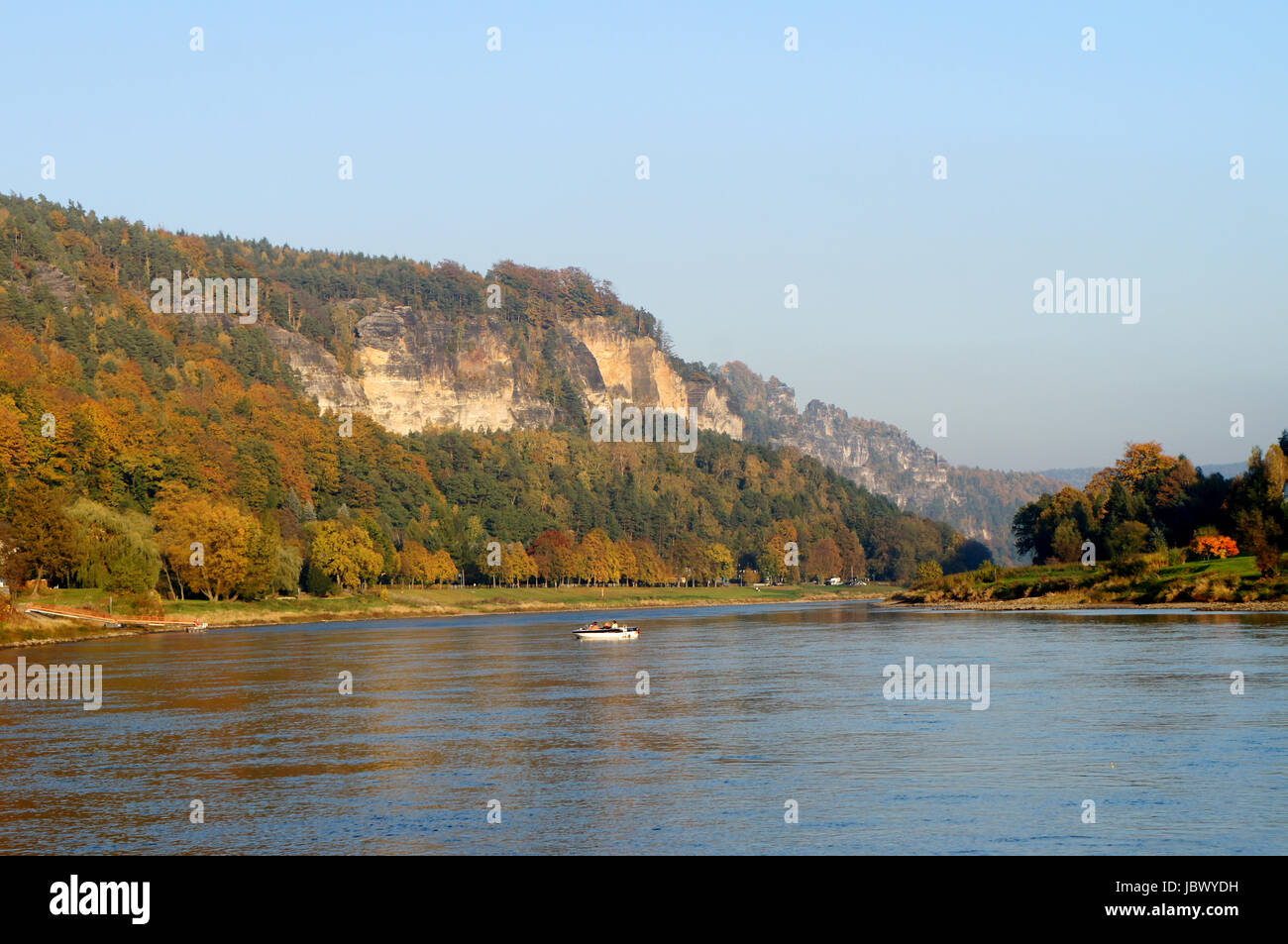 Die Elbe im deutschen Teil des Elbsandsteingebirges; steile Felsen und bunte Laubwälder; auf dem Fluss ein Boot The Elbe river in the German part of the Elbe Sandstone Mountains; steep rocks and colorful deciduous forests; on the river a boat Stock Photo