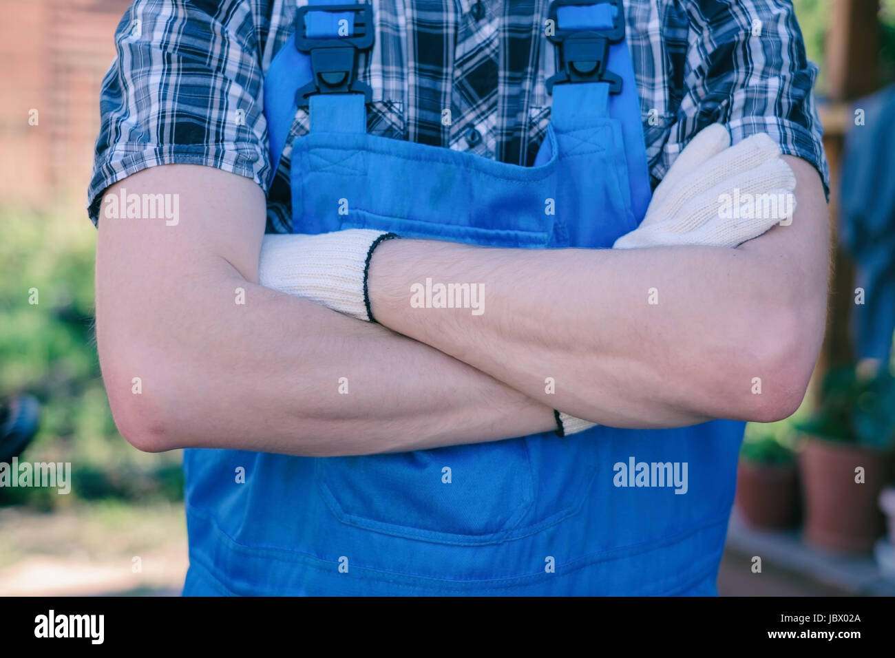 Young gardener in dungarees ready for work Stock Photo
