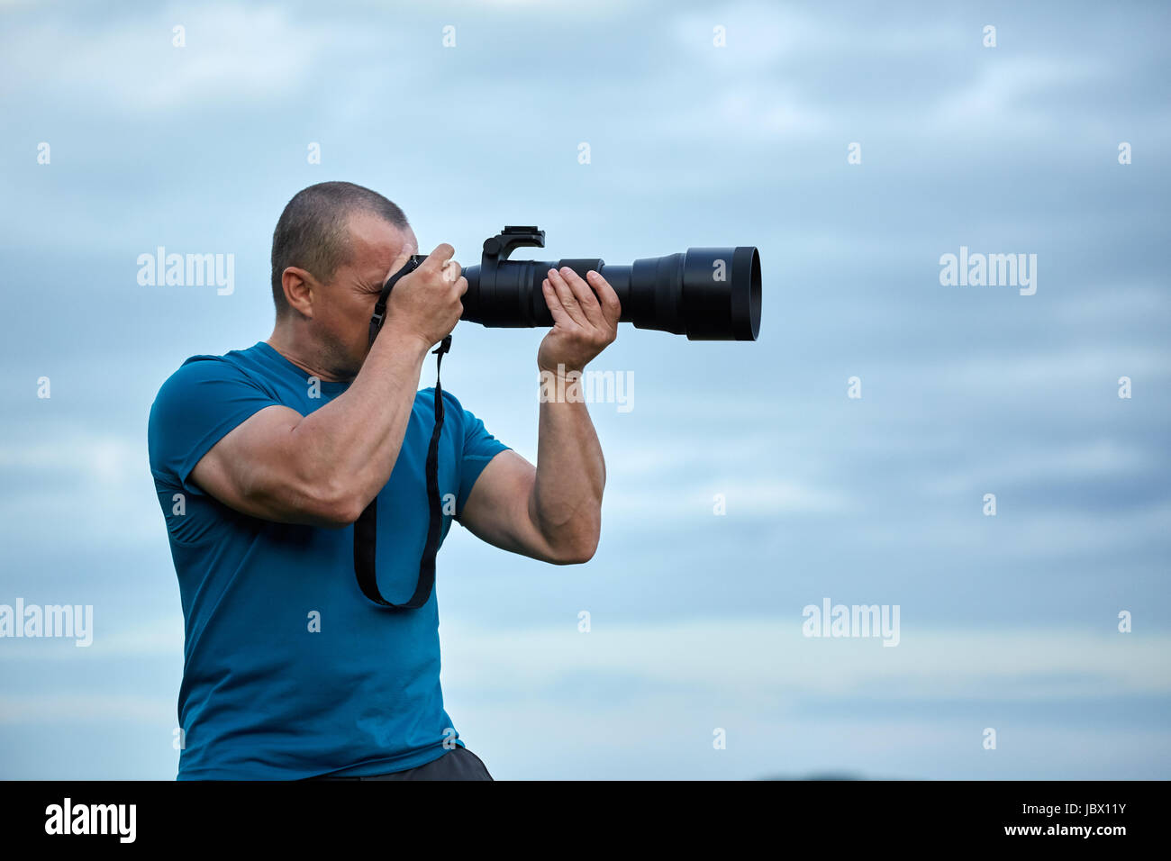 Wildlife photographer with a big telephoto lens on camera Stock Photo