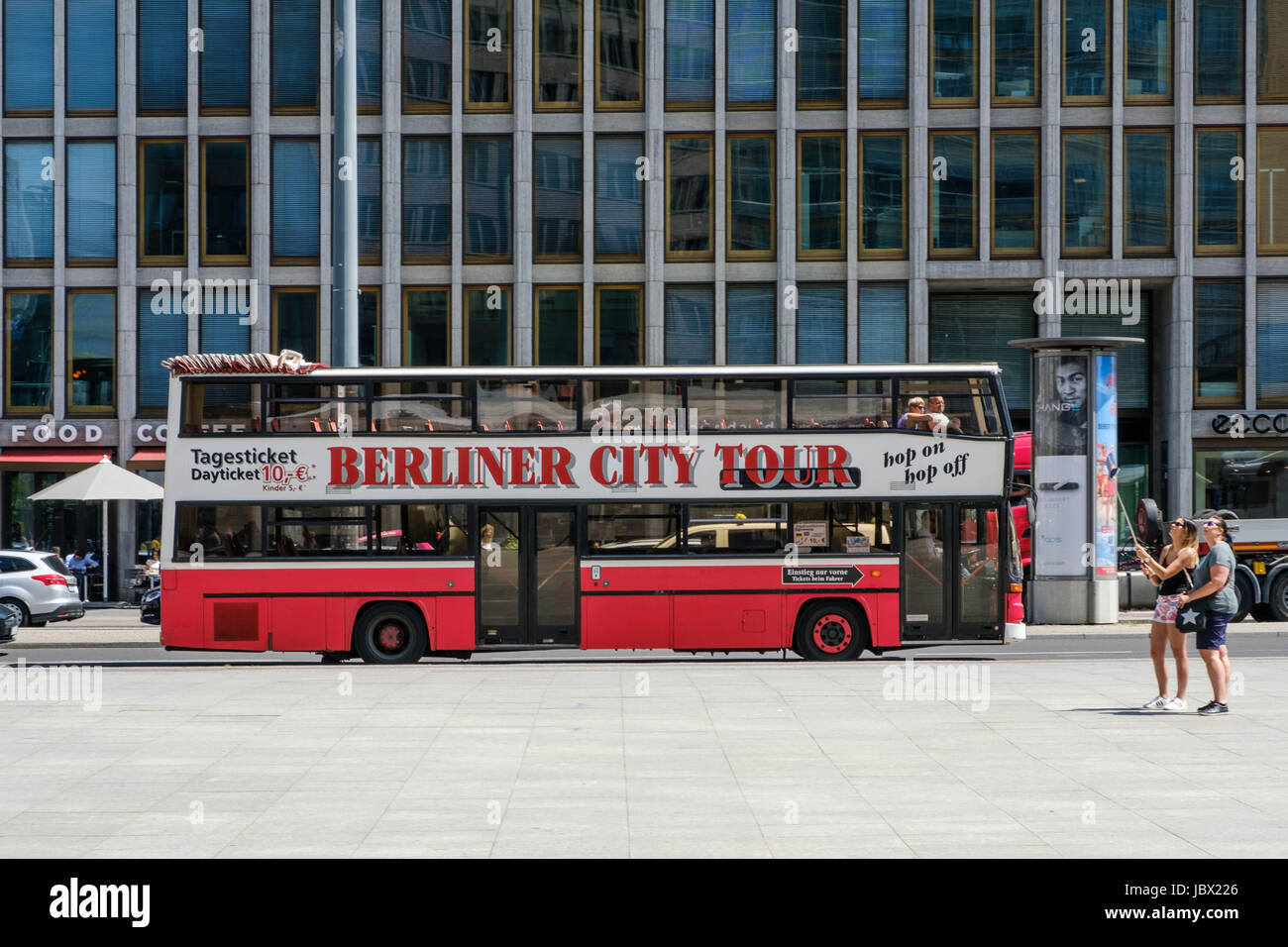 Berlin, Germany - june 9, 2017: A sightseeing bus offering Berlin City Tours with two tourists making a selfie with selfie stick in foreground at  Pot Stock Photo