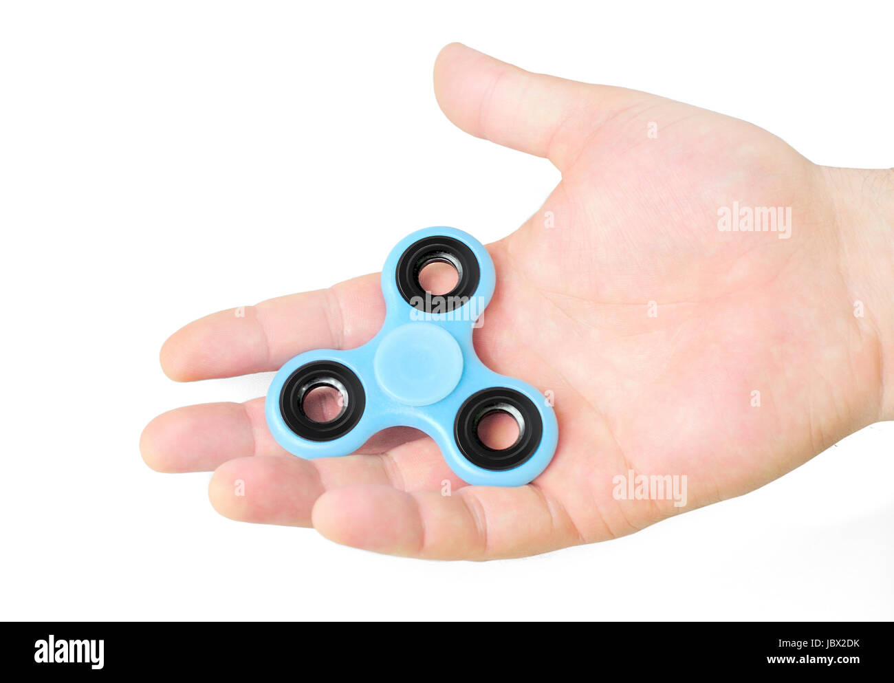 Male hand holding blue fidget spinner in palm, isolated on white background Stock Photo