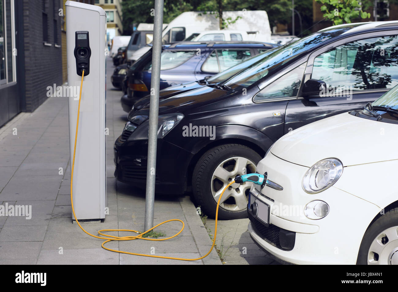 Recharge. Electric Car in Free Charging Station. Environmentally Friendly Transport Stock Photo