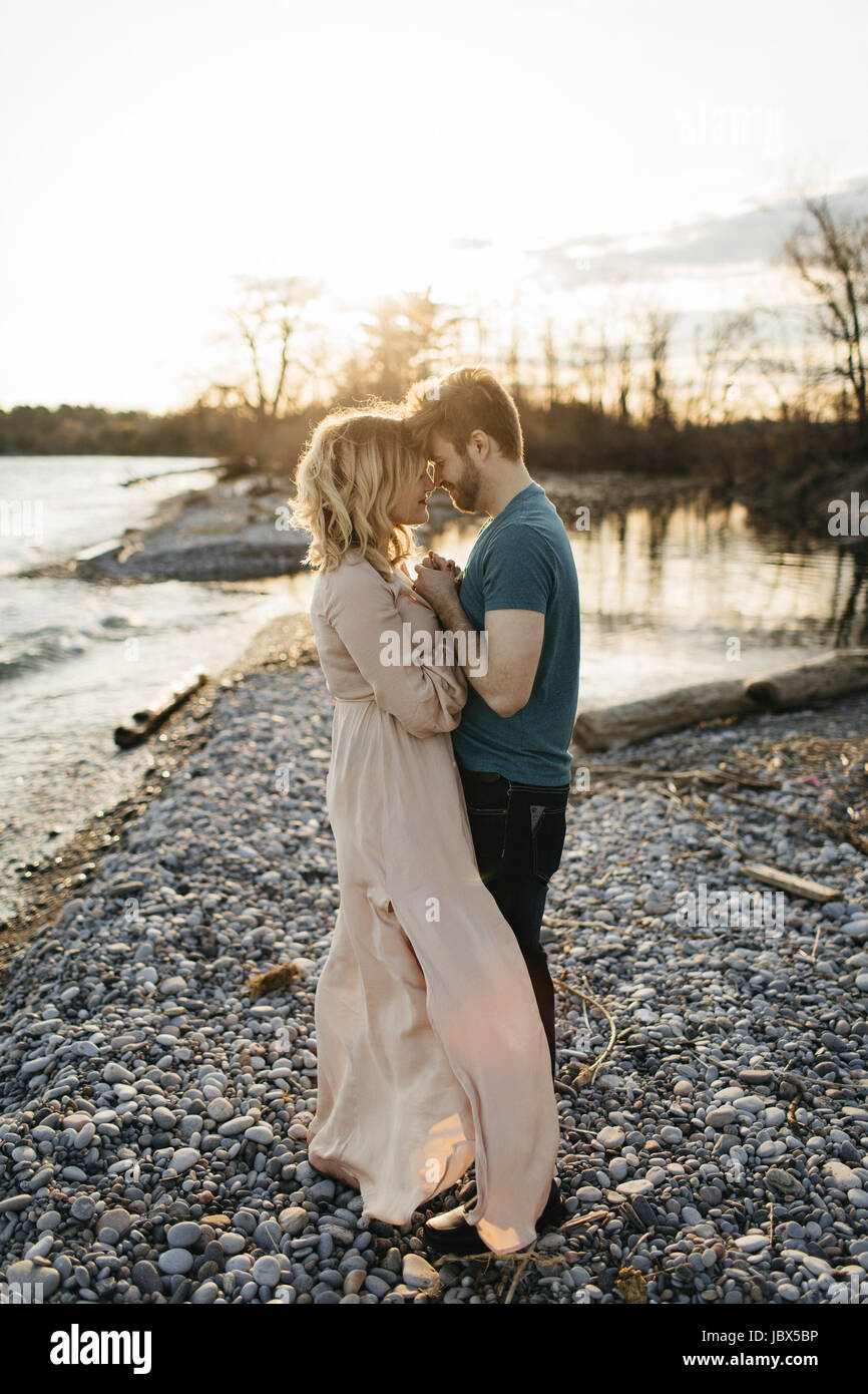 Couple beside lake, face to face, holding hands Stock Photo