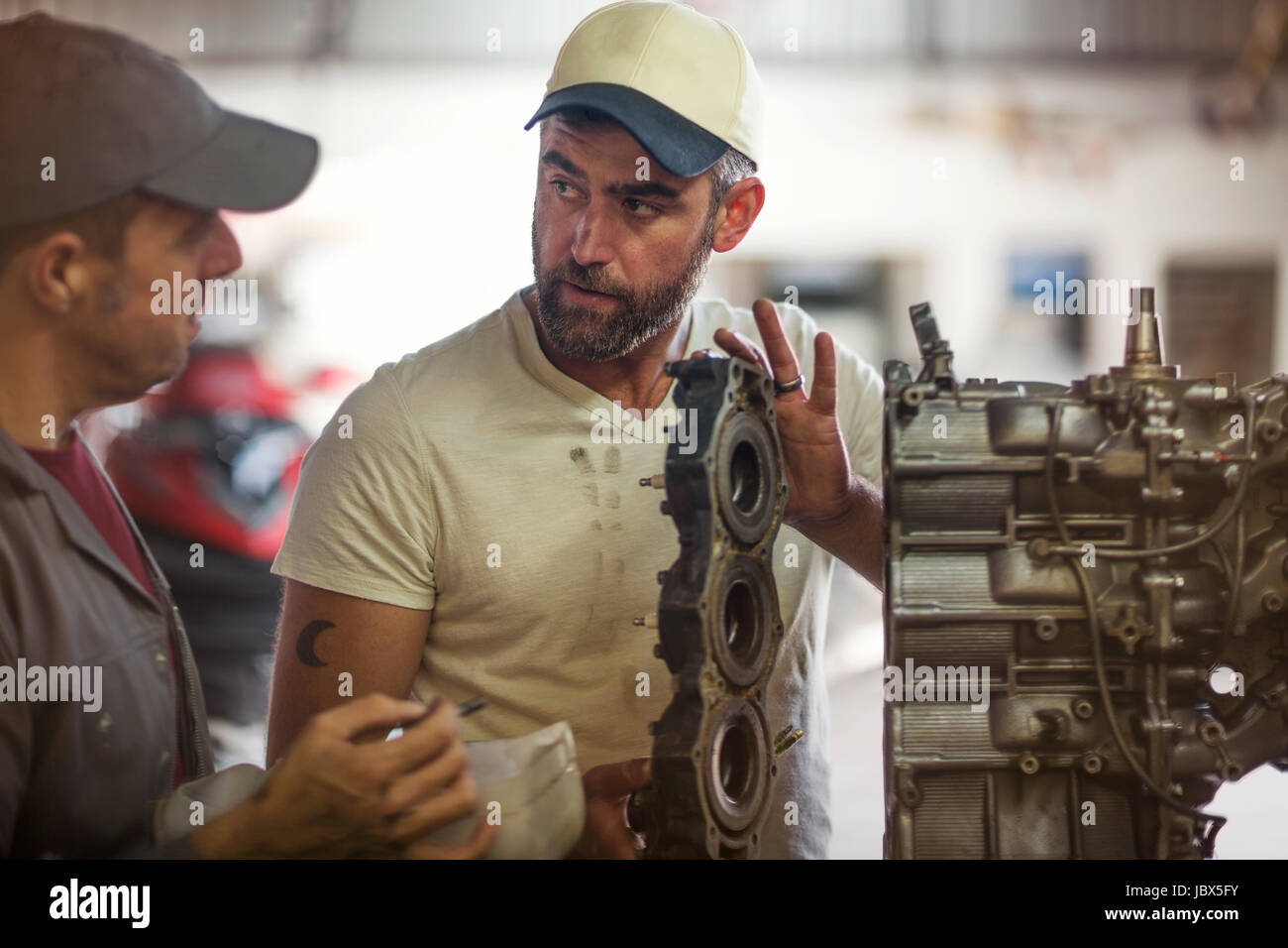 Two men repairing outboard motor in boat repair Stock Photo