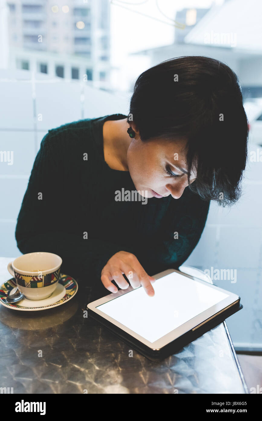 Woman in cafe using touchscreen on digital tablet Stock Photo - Alamy