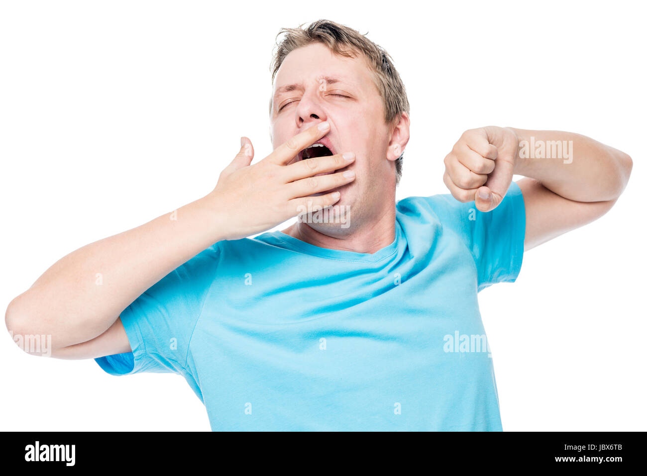 Sleepy man yawning and stretching before bed on white background Stock
