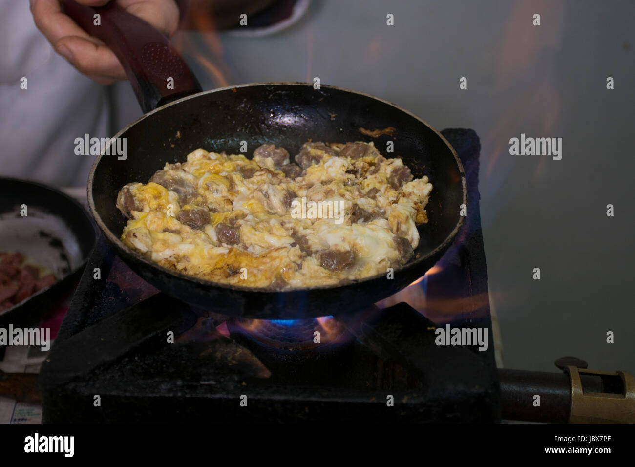 Fried eggs and lamb liver in a pan inside a Lebanese restaurant Stock Photo