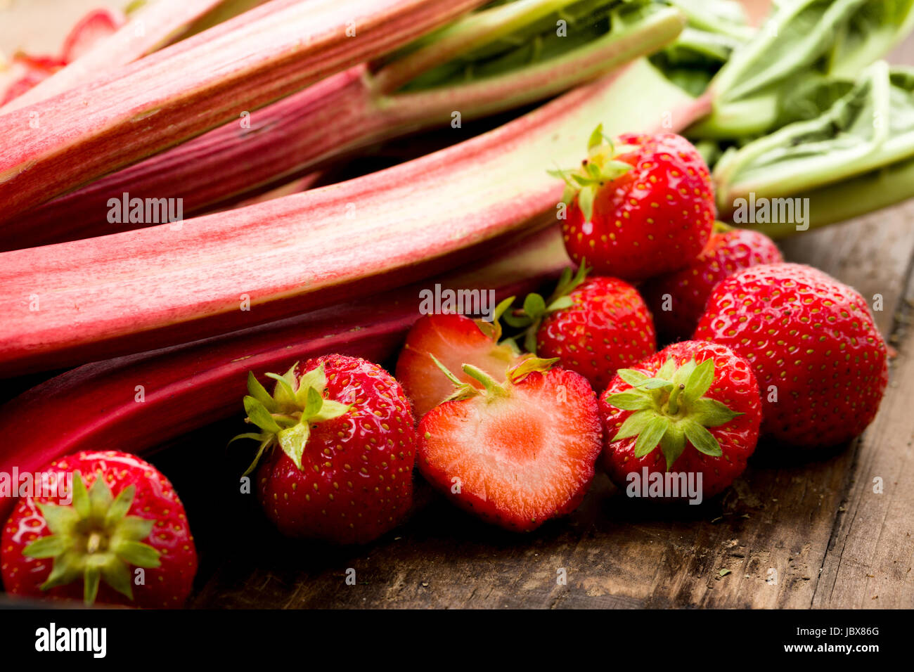 Frischer Rhababer und Erdbeeren auf einen Holz untergrund Stock Photo