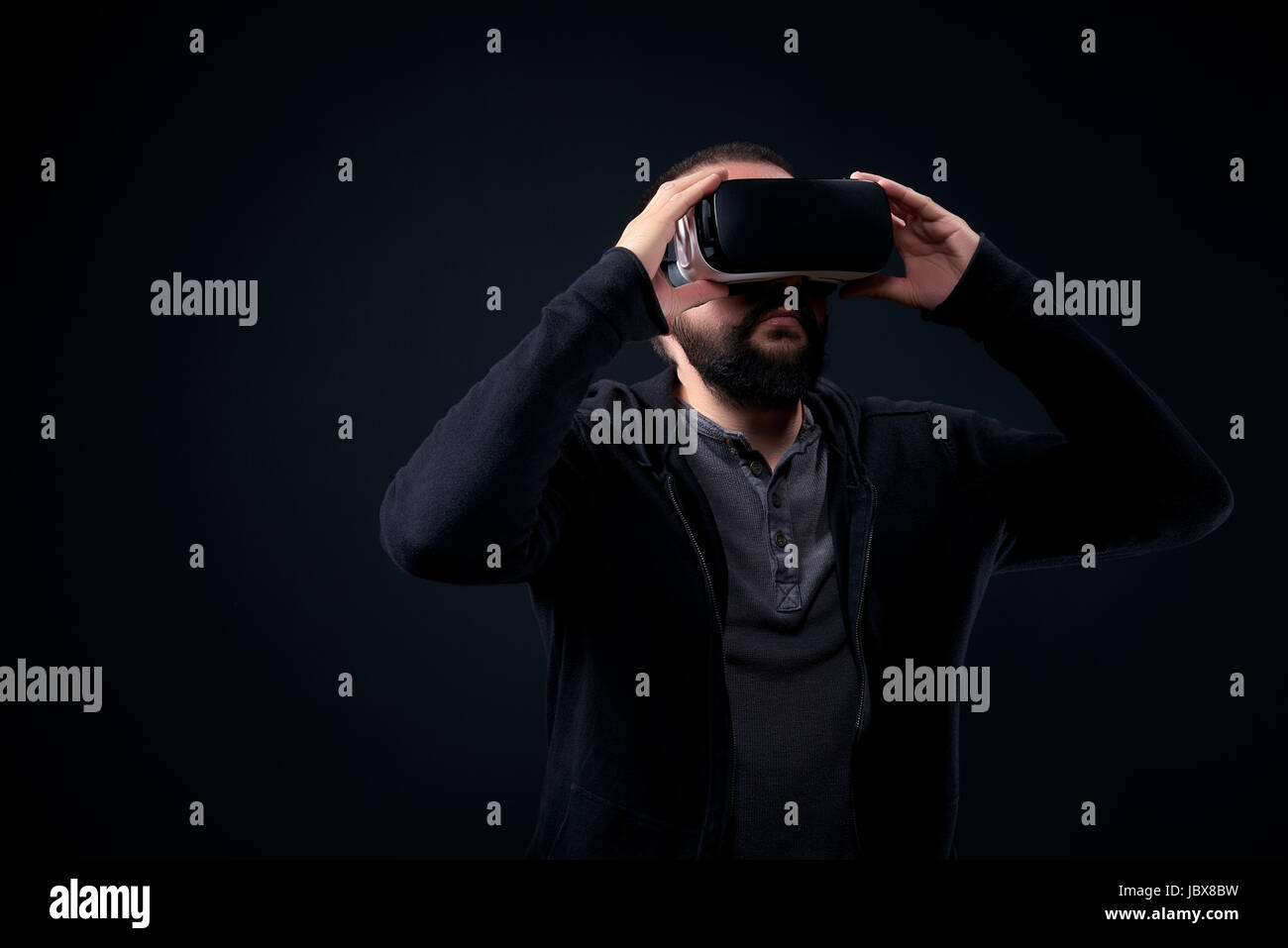 Young hipster bearded man wearing virtual reality goggles. Black ...