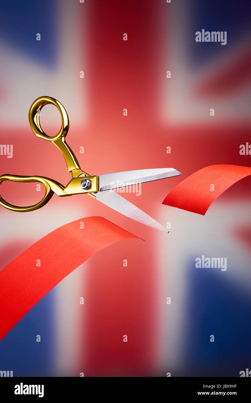 Golden scissors cutting red ribbon, symbolising brexit Stock Photo