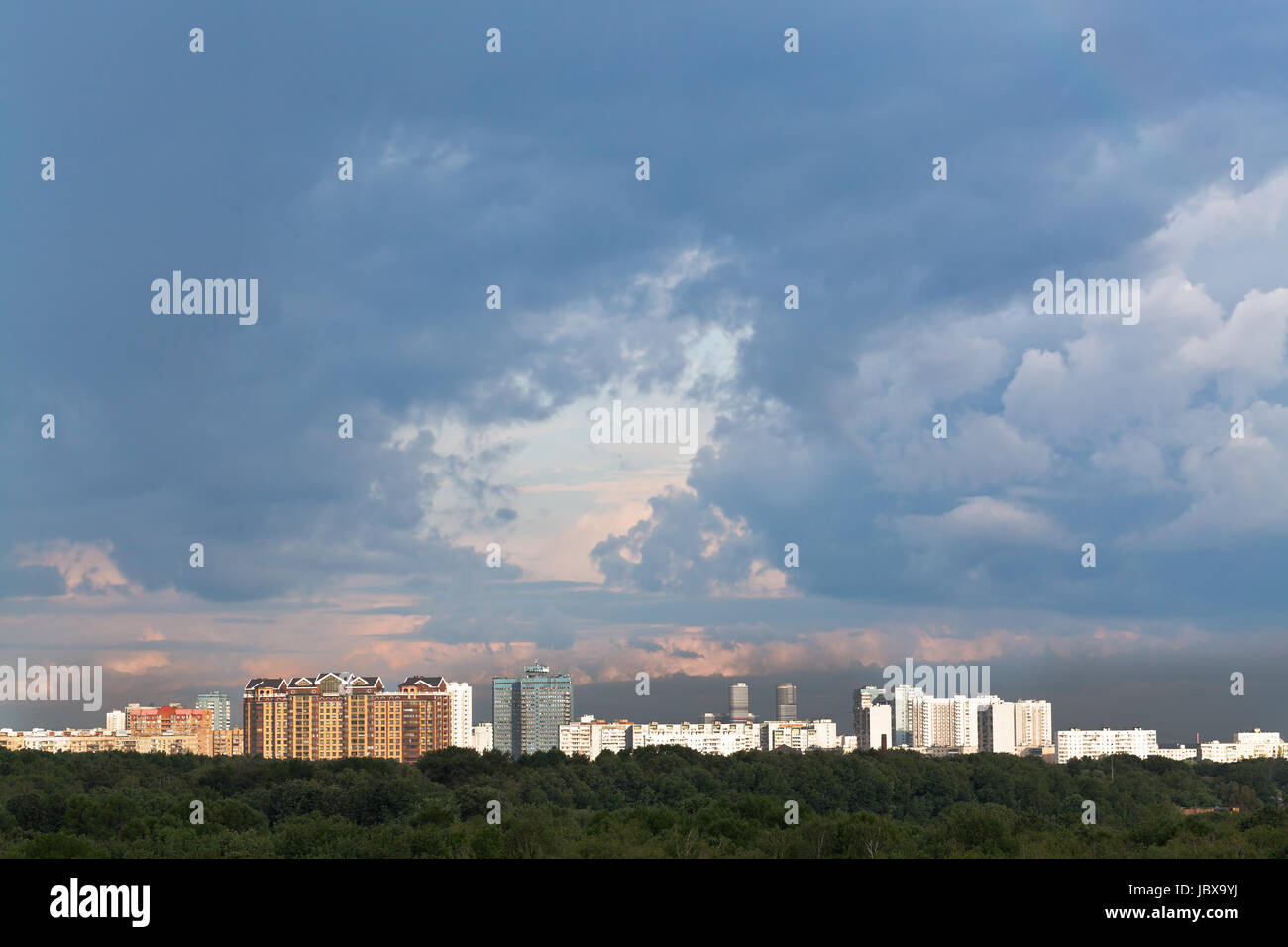 dark blue rainy clouds in sunset sky over city in summer evening Stock ...