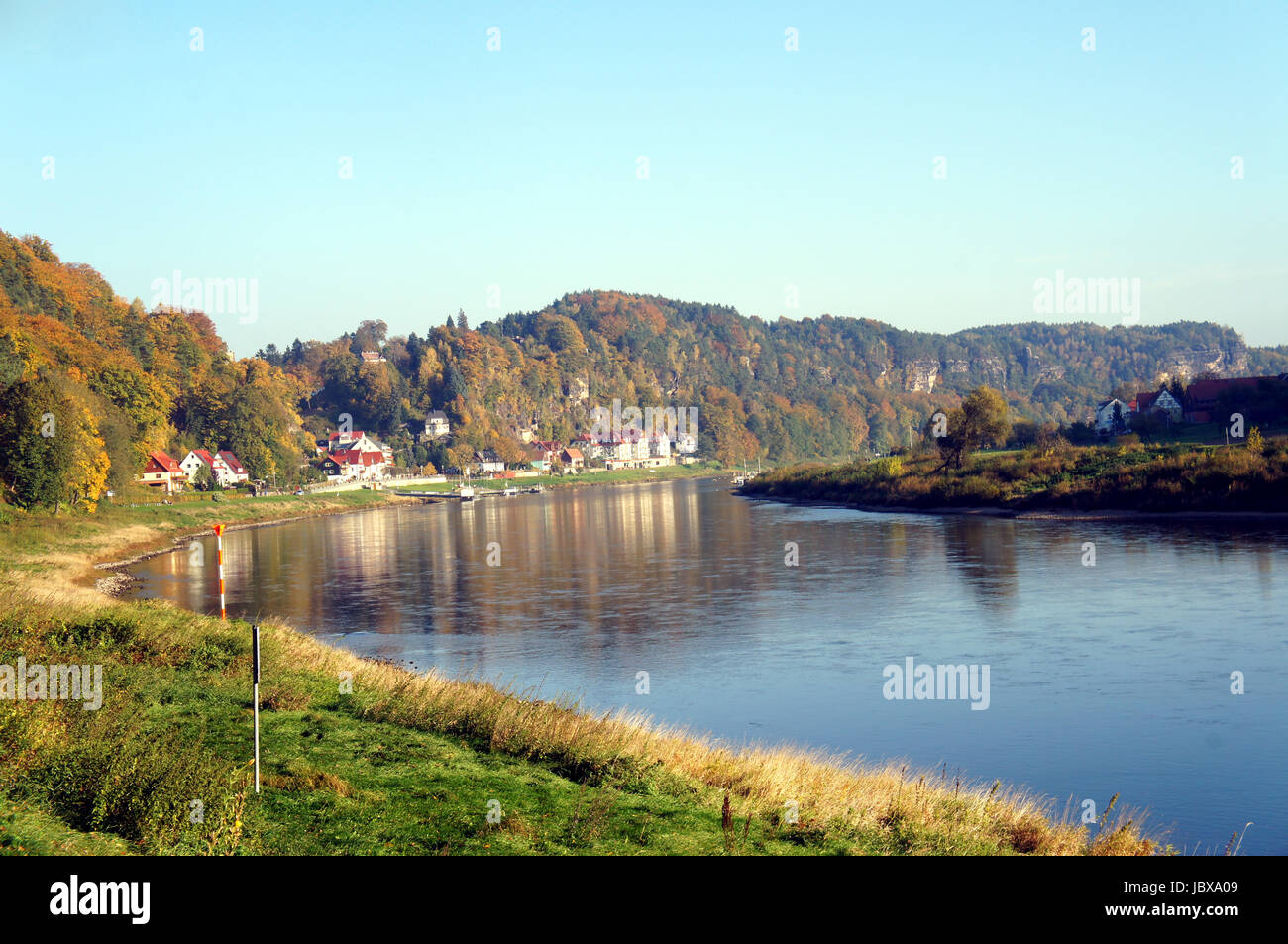 Die Elbe im deutschen Teil des Elbsandsteingebirges; steile Felsen und bunte Laubwälder; am Ufer ein kleiner Kurort  The Elbe river in the German part of the Elbe Sandstone Mountains; steep rocks and colorful deciduous forests; on the banks a small spa town Stock Photo