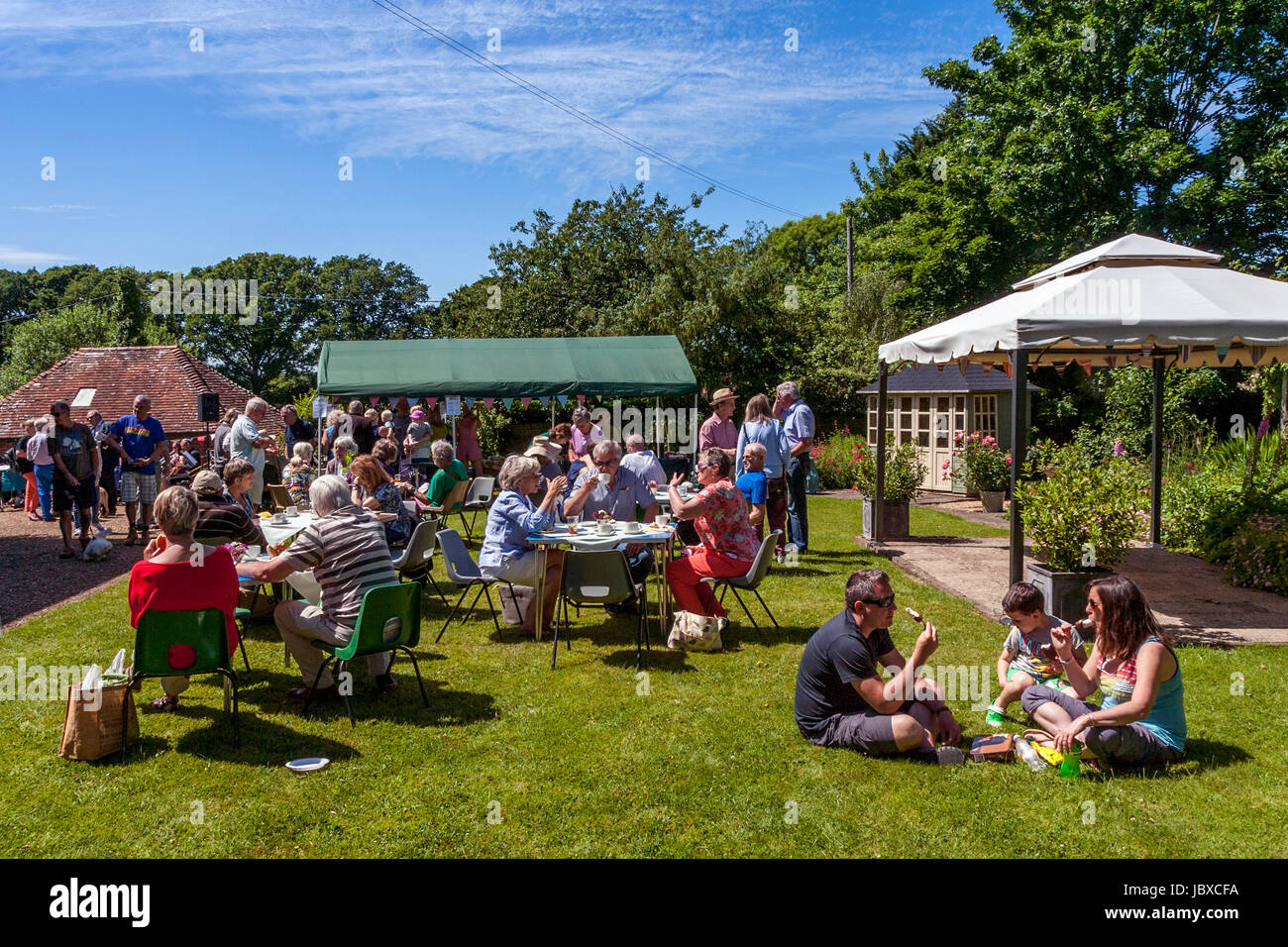 People Enjoying Cream Teas On The Lawns Of Chiddingly Vicarage During The Annual Chiddingly Fete, Chiddingly, Sussex, UK Stock Photo
