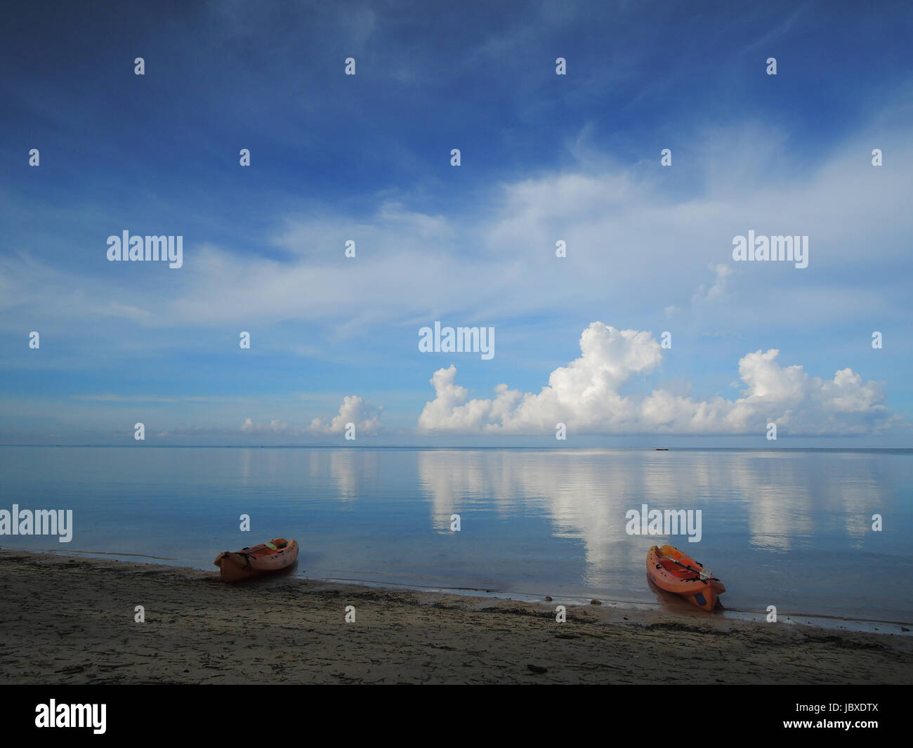 Ocean view from white sand beach with kayaks Stock Photo