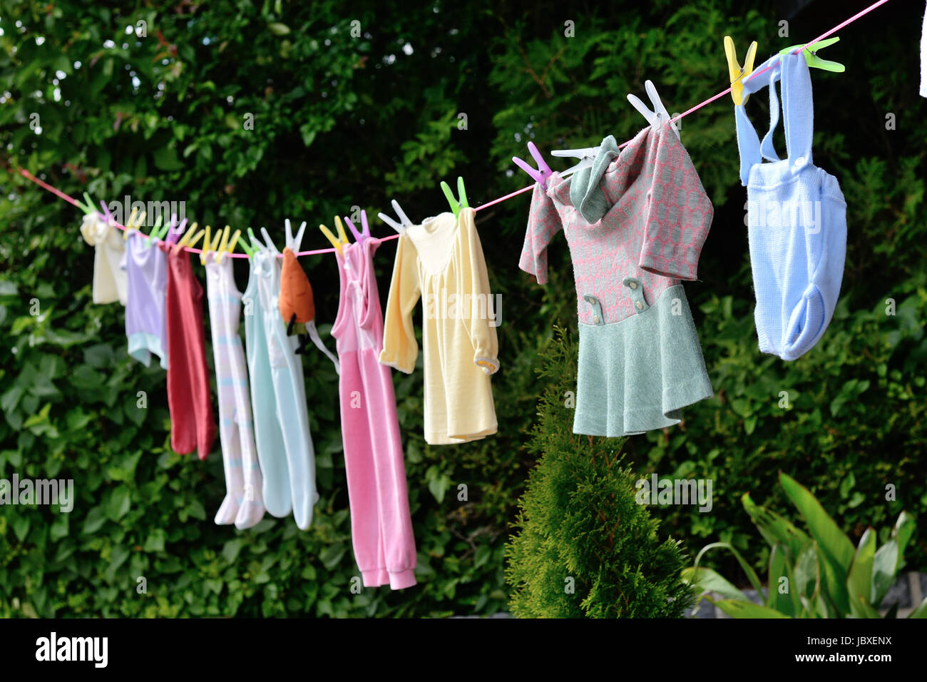 alter Brauch - auf Waescheleine haengende Babykleidung als Geschenk fuer  Nachwuchs Stock Photo - Alamy