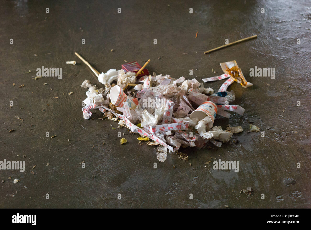 Rubbish swept into pile on floor of canteen, Yunnan, China Stock Photo