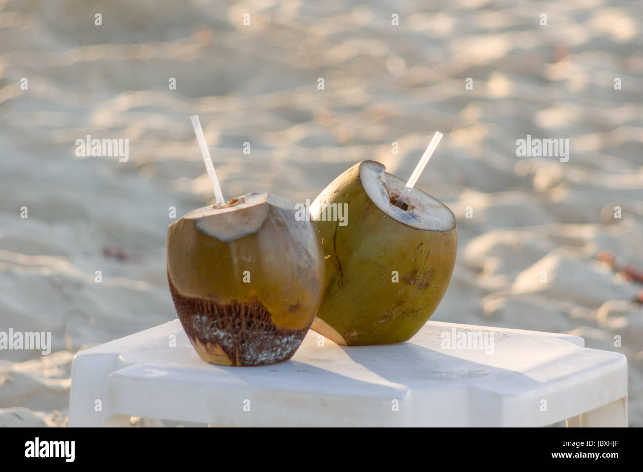 Coconut drink with fresh coconuts with a drinking straw Stock Photo Alamy