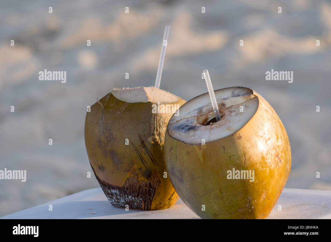 Coconut drink with fresh coconuts with a drinking straw Stock Photo Alamy
