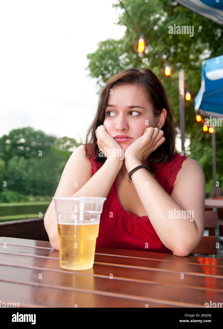 traurige Frau mit Bier Stock Photo