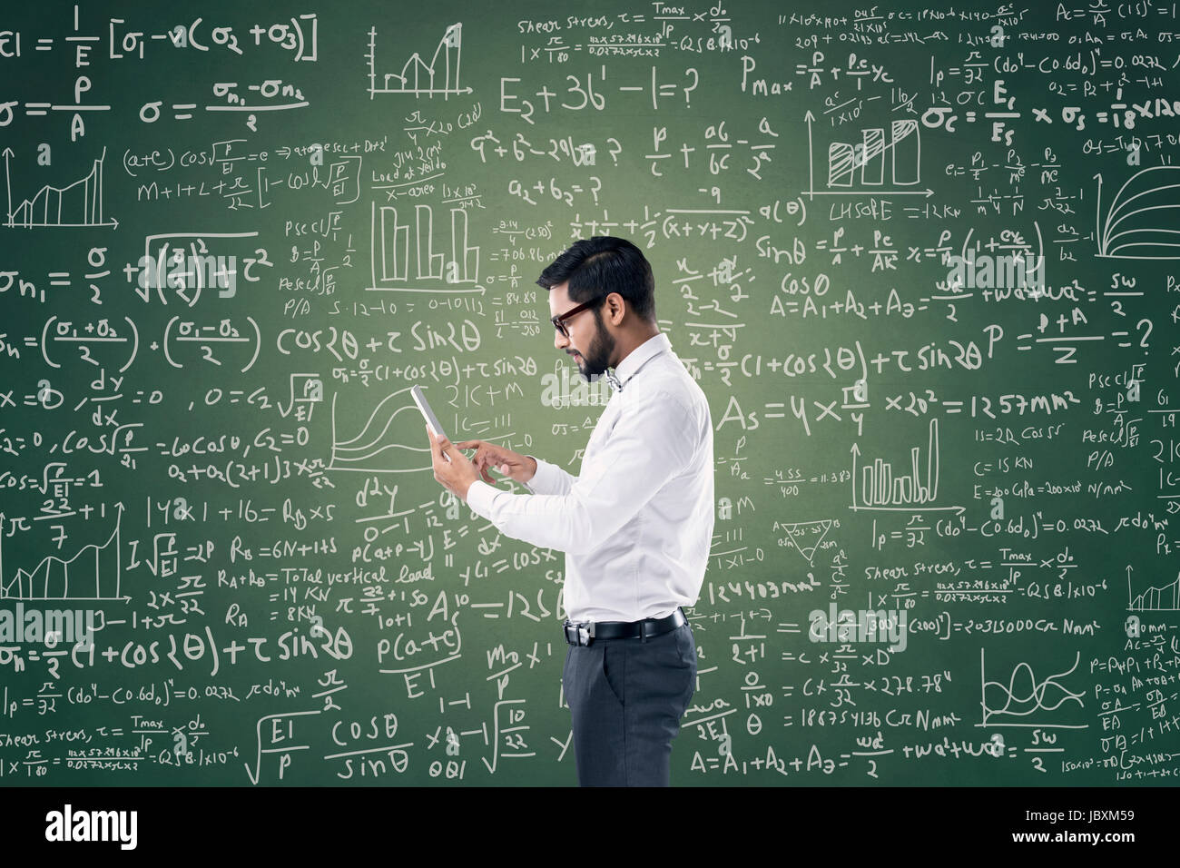 Young Businessman Holding Digital Tablet In Front Of Chalkboard With Mathematical Formula Stock Photo Alamy