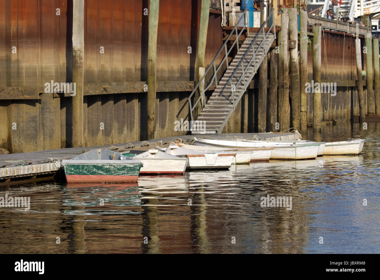 Dories tied to the fishing pier at Perkins Cove, Ogunquit, Maine.  These small boats are used by fisherman to and from their lobster boats. Stock Photo