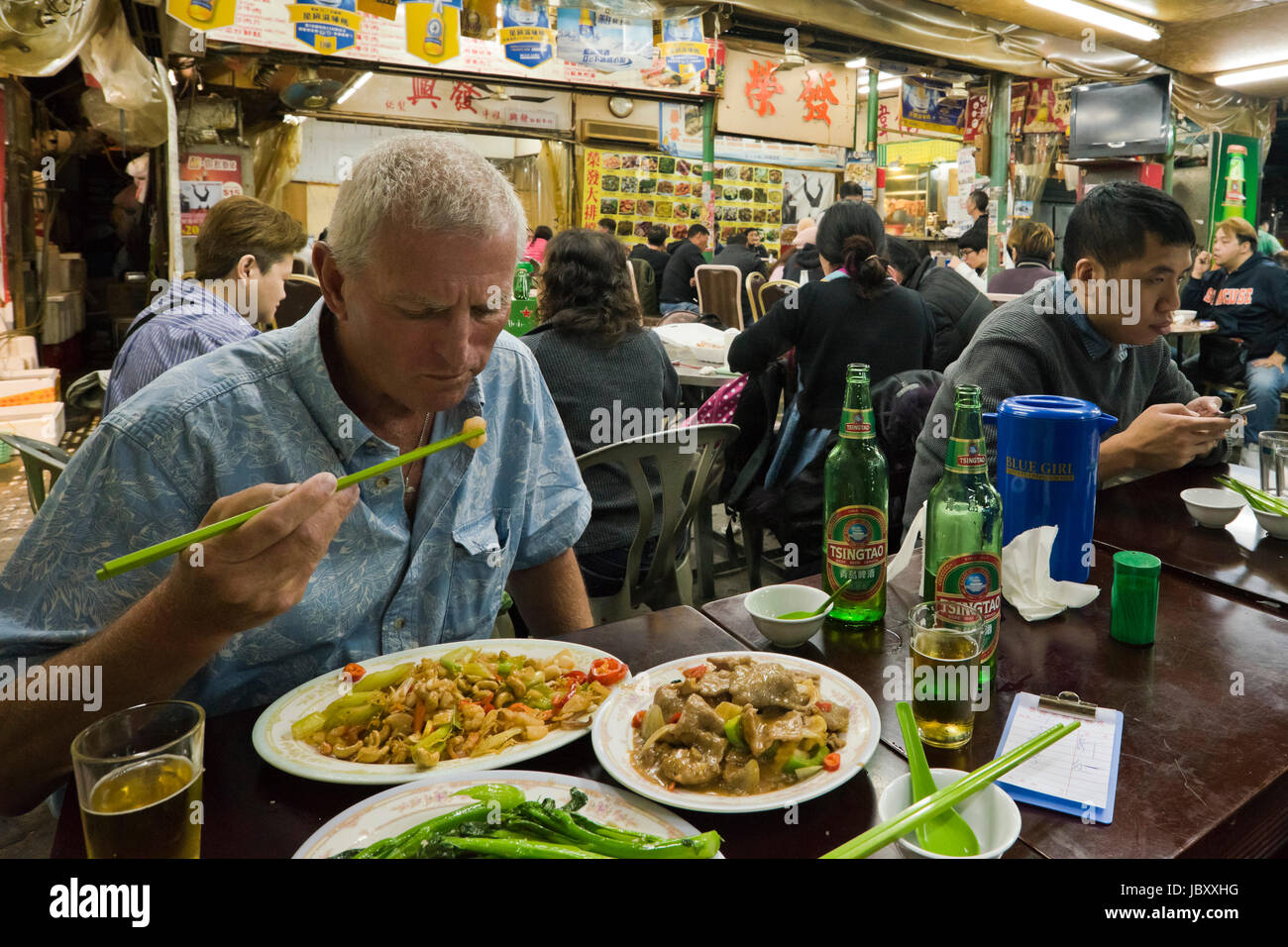 Horizontal view inside a bustling streetfood restaurant in Hong Kong, China. Stock Photo