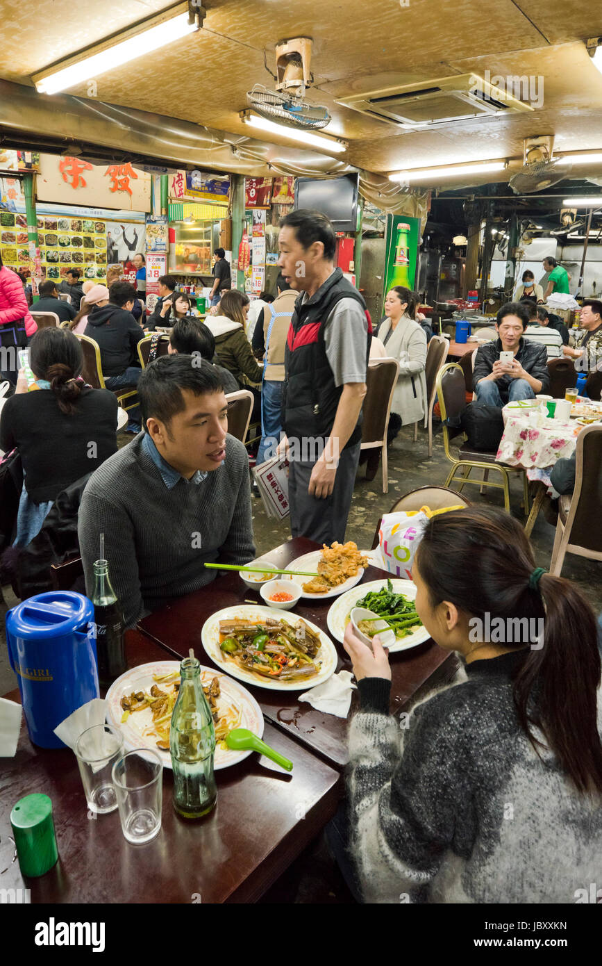 Vertical view inside a bustling streetfood restaurant in Hong Kong, China. Stock Photo
