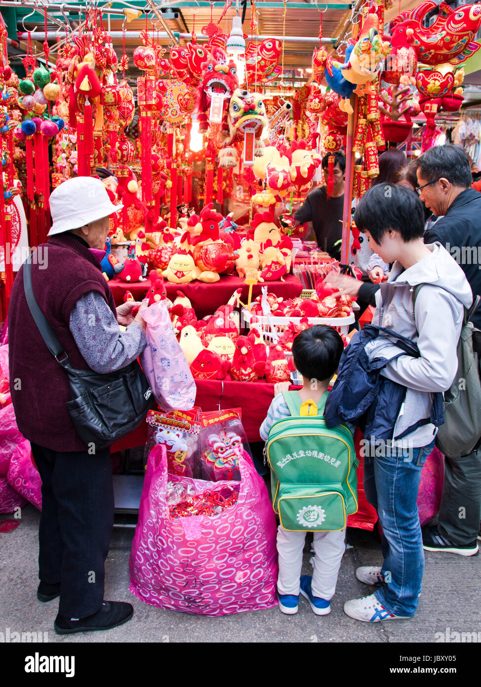 Vertical view of a family choosing Chinese New Year decorations at a market stall in Hong Kong, China. Stock Photo