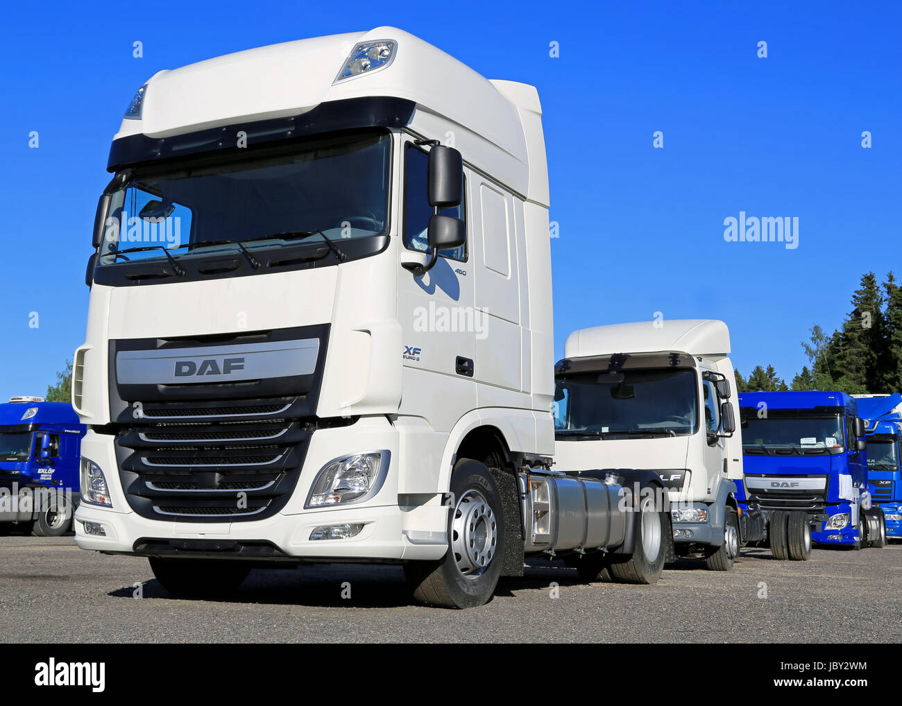 RAJAMAKI, FINLAND - JUNE 28, 2014: New, white DAF XF Euro 6 truck on a yard with a group of DAF trucks. The new XF is powered by PACCAR MX-13 and MX-11 engines. Stock Photo