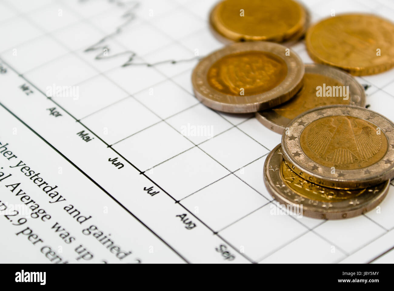 Close-up of several coins on a financial stock-exchange chart in a news magazin Stock Photo