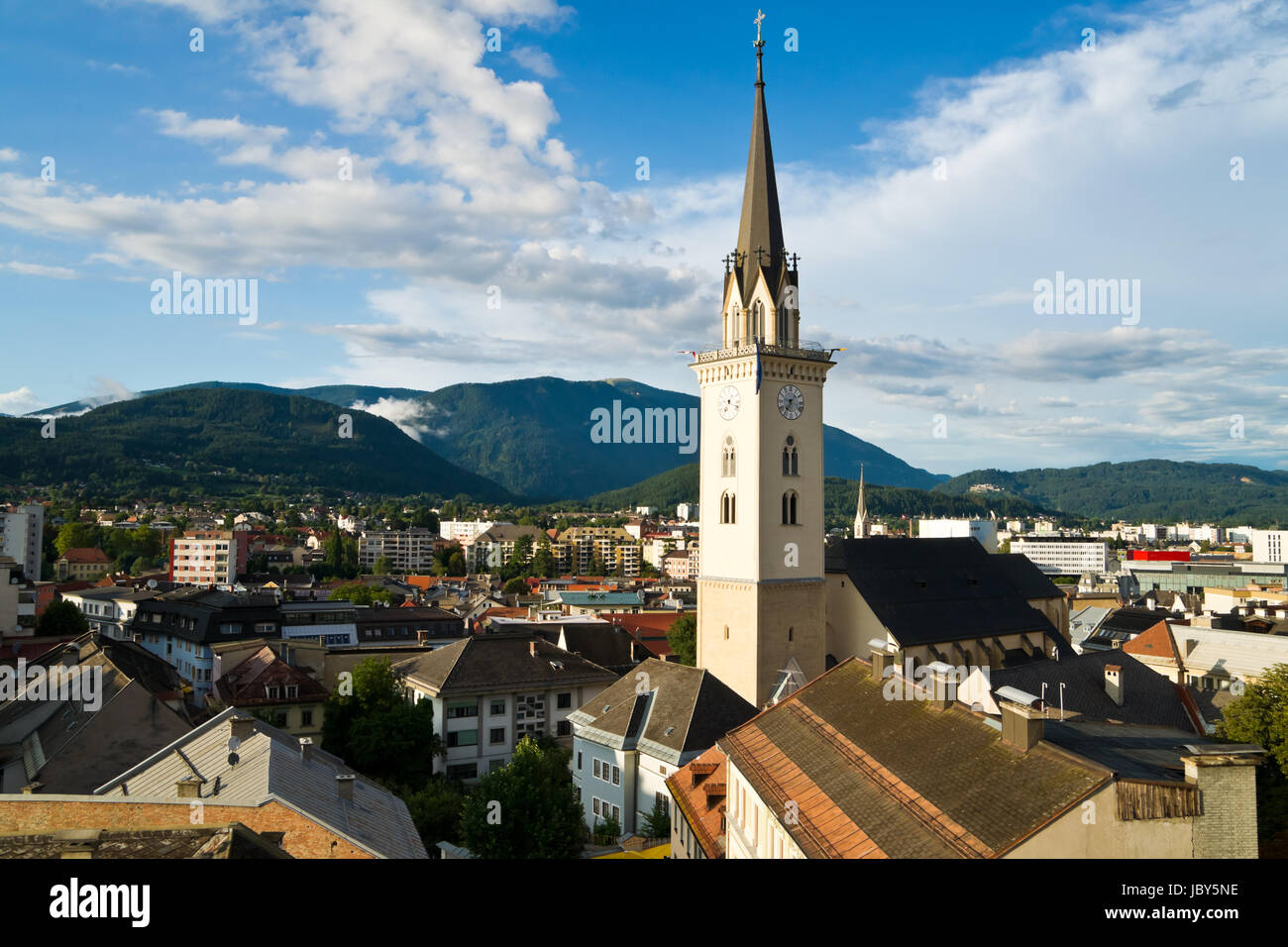 Aerial view over the town center and the biggest church of Villach in Carinthia/Austria on a sunny day. Villach belongs to the largest cities of Austria and is nicely surrounded by several mountains. Stock Photo