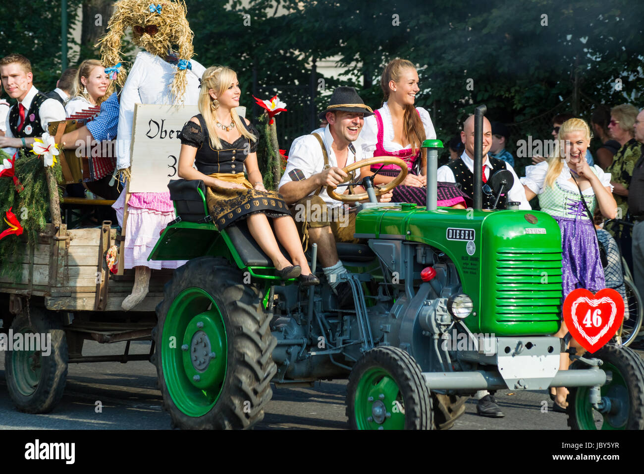 VILLACH, AUSTRIA - AUGUST 4: Participants riding a tractor at the procession of 'Villacher Kirchtag', the largest traditional folk festival in Austria, August 4, 2012 in Villach, Austria. Stock Photo