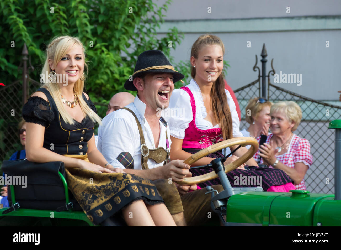 VILLACH, AUSTRIA - AUGUST 4: Participants riding a tractor at the procession of 'Villacher Kirchtag', the largest traditional folk festival in Austria, August 4, 2012 in Villach, Austria. Stock Photo
