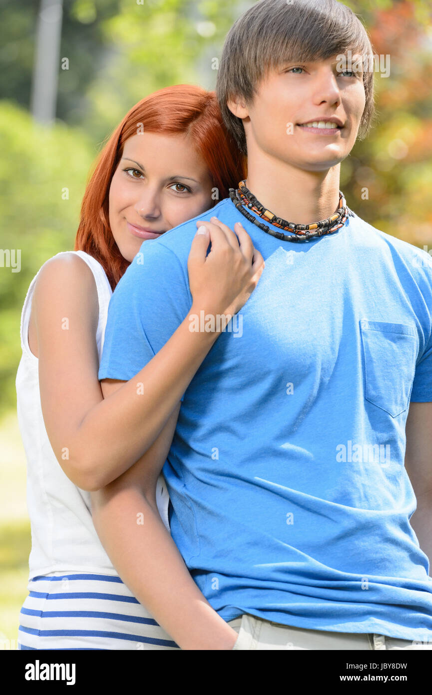 Teenage girlfriend hugging her boyfriend from behind sunny park Stock ...