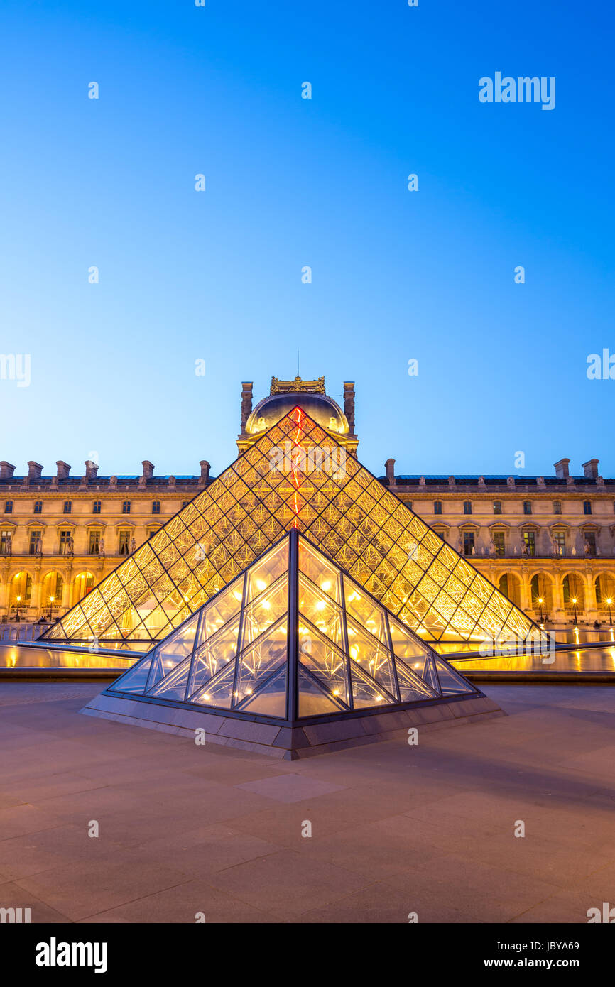 Paris - June 18: Louvre museum at dusk on June 18, 2014 in Paris. This is one of the most popular tourist destinations in France displayed over 60,000 square meters of exhibition space.. Stock Photo