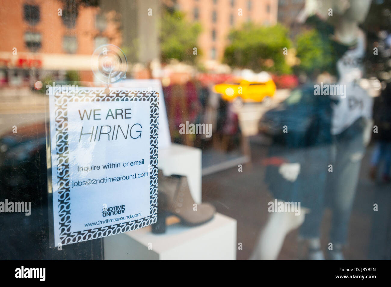 A hiring sign in the window of a shuttered 2nd Time Around
