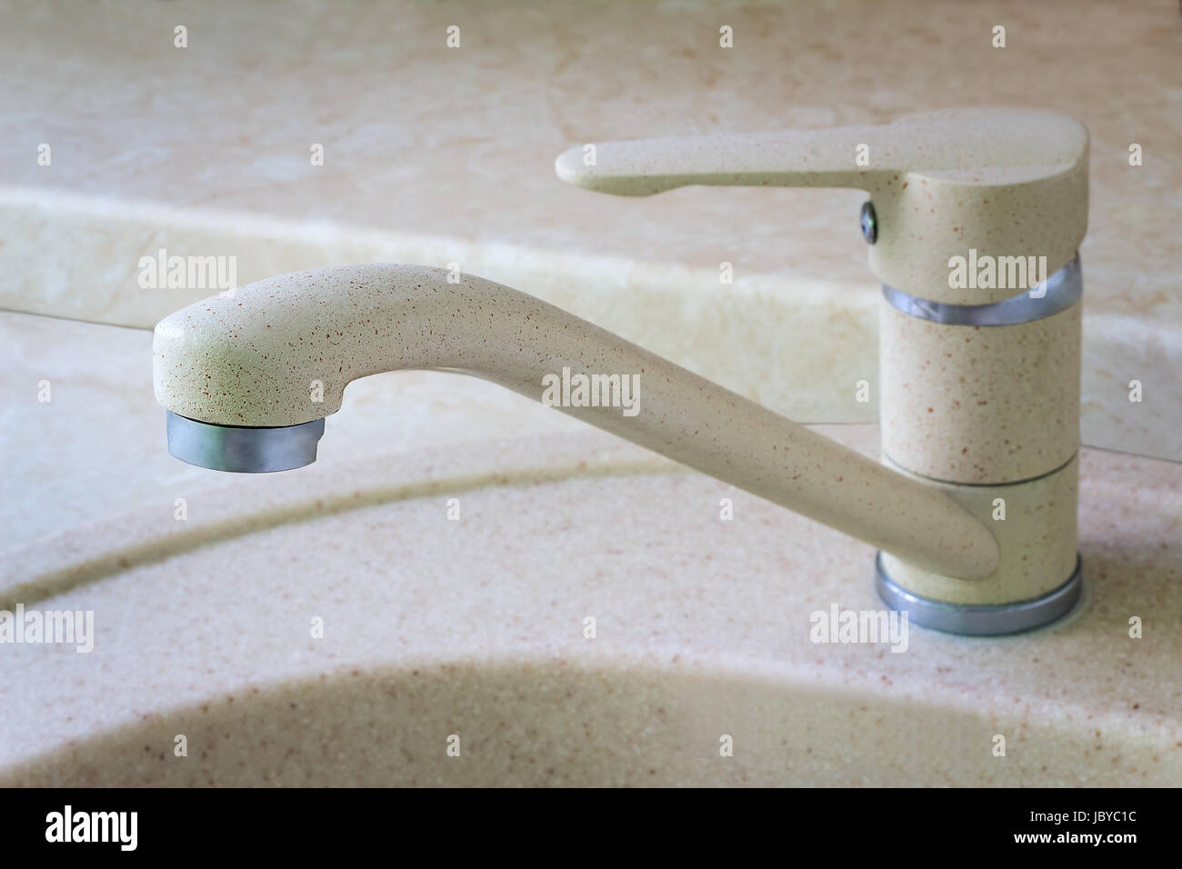 The crane for water is installed on a sink for ware. Stock Photo