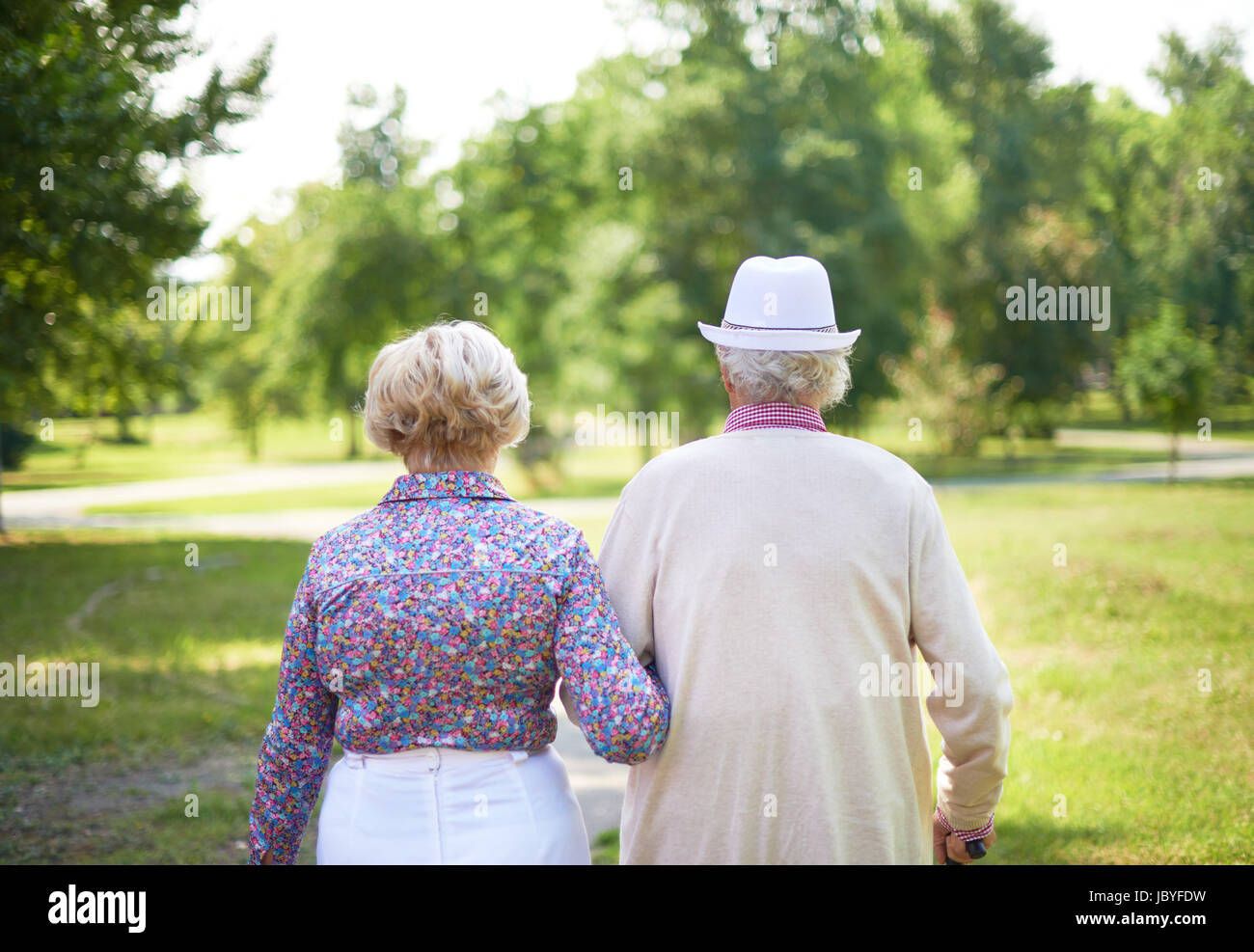 Back view of serene senior couple taking a walk in the park Stock Photo ...