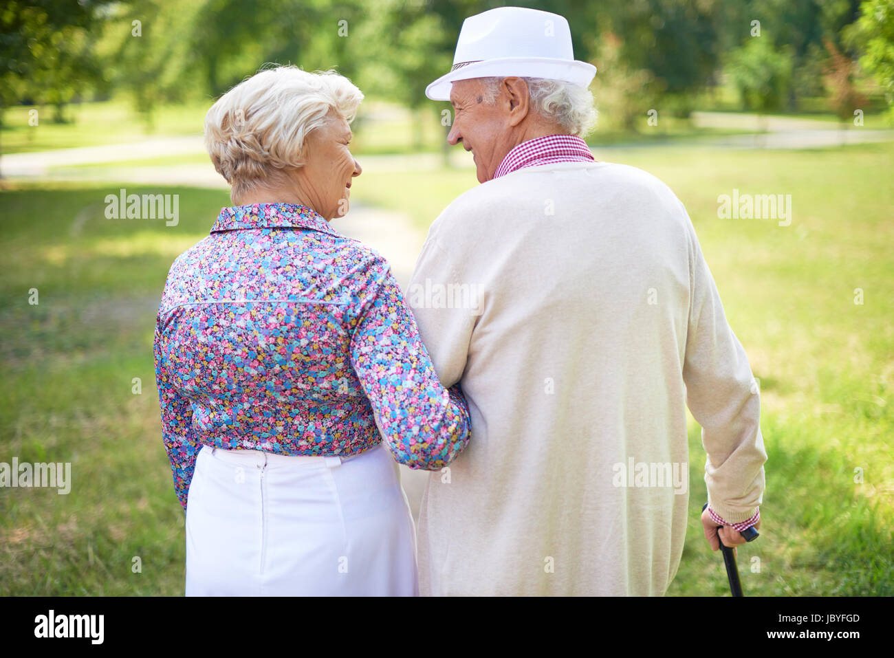 Back view of happy senior couple talking while taking a walk in the ...