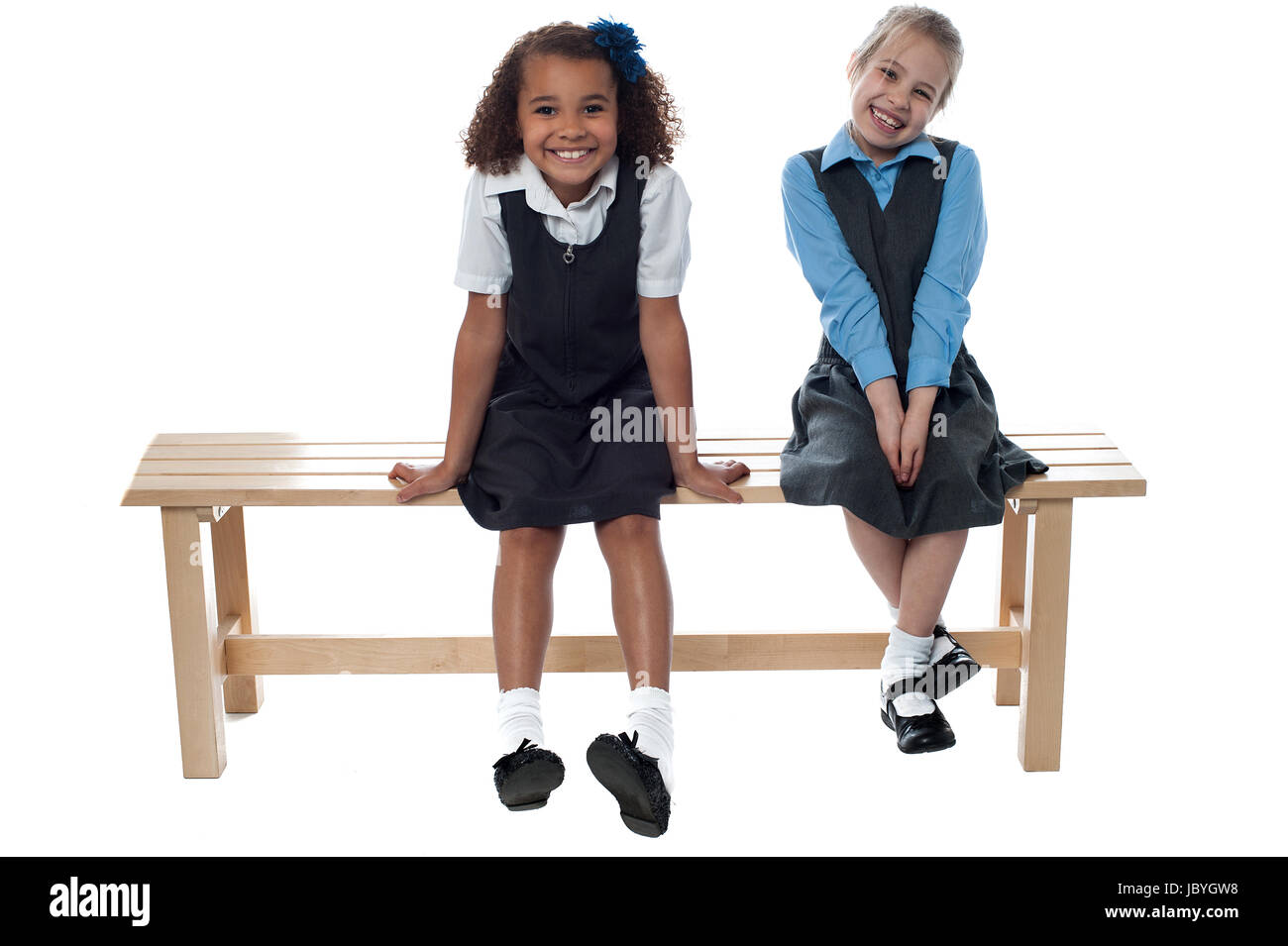 Two cute girls laughing sitting on a bench Stock Photo - Alamy