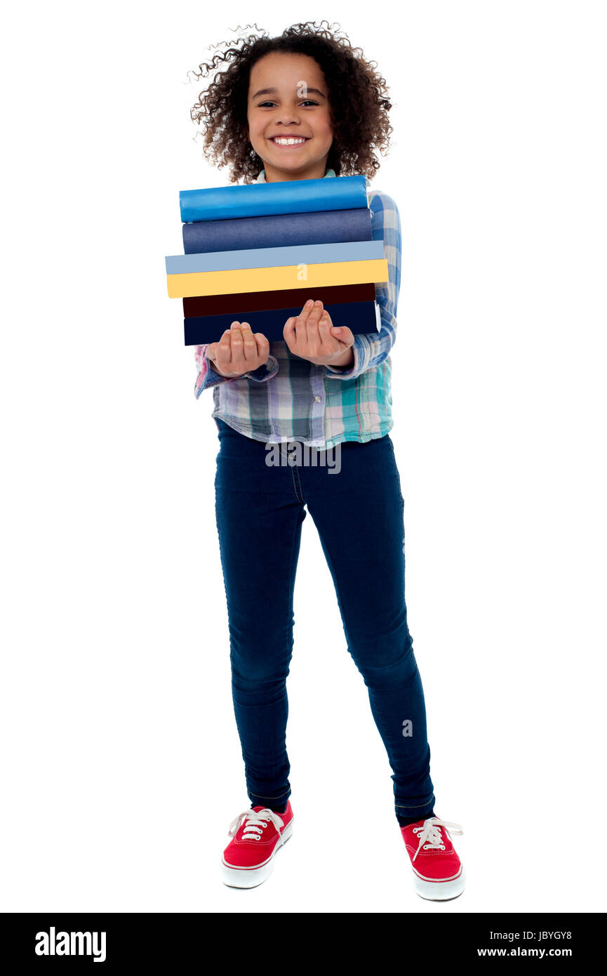 Smiling little girl holding stack of school books Stock Photo - Alamy
