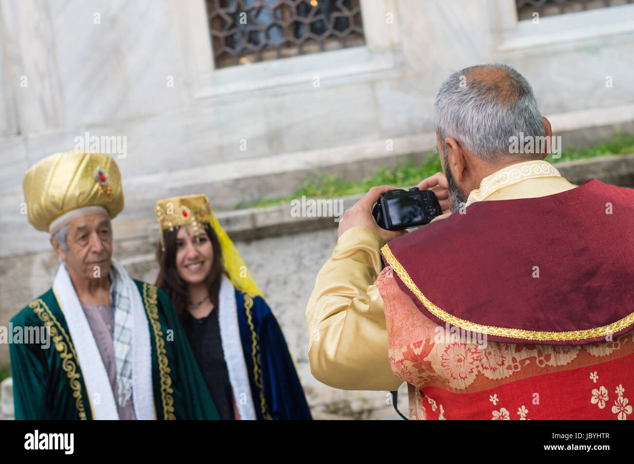 traditional turkish man taking pics of some dressed tourists. Istanbul is one of the most important tourism spots not only in Turkey but also in the world. Stock Photo