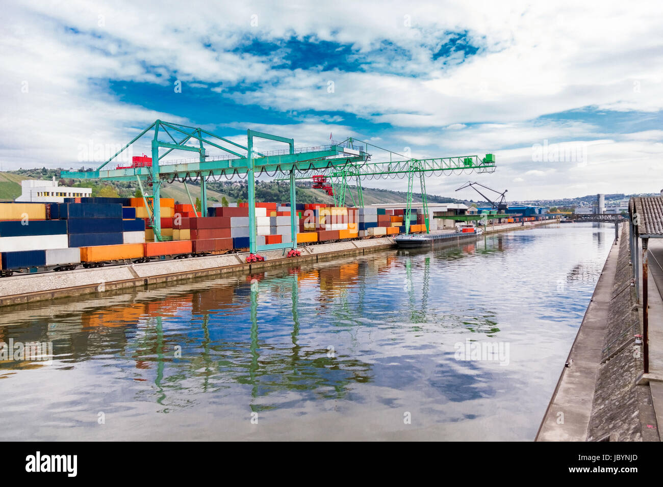 Anlegestelle im Hafen mit gestapelten Containern am Dock für Import und Export Cargo mit blauem Himmel Stock Photo